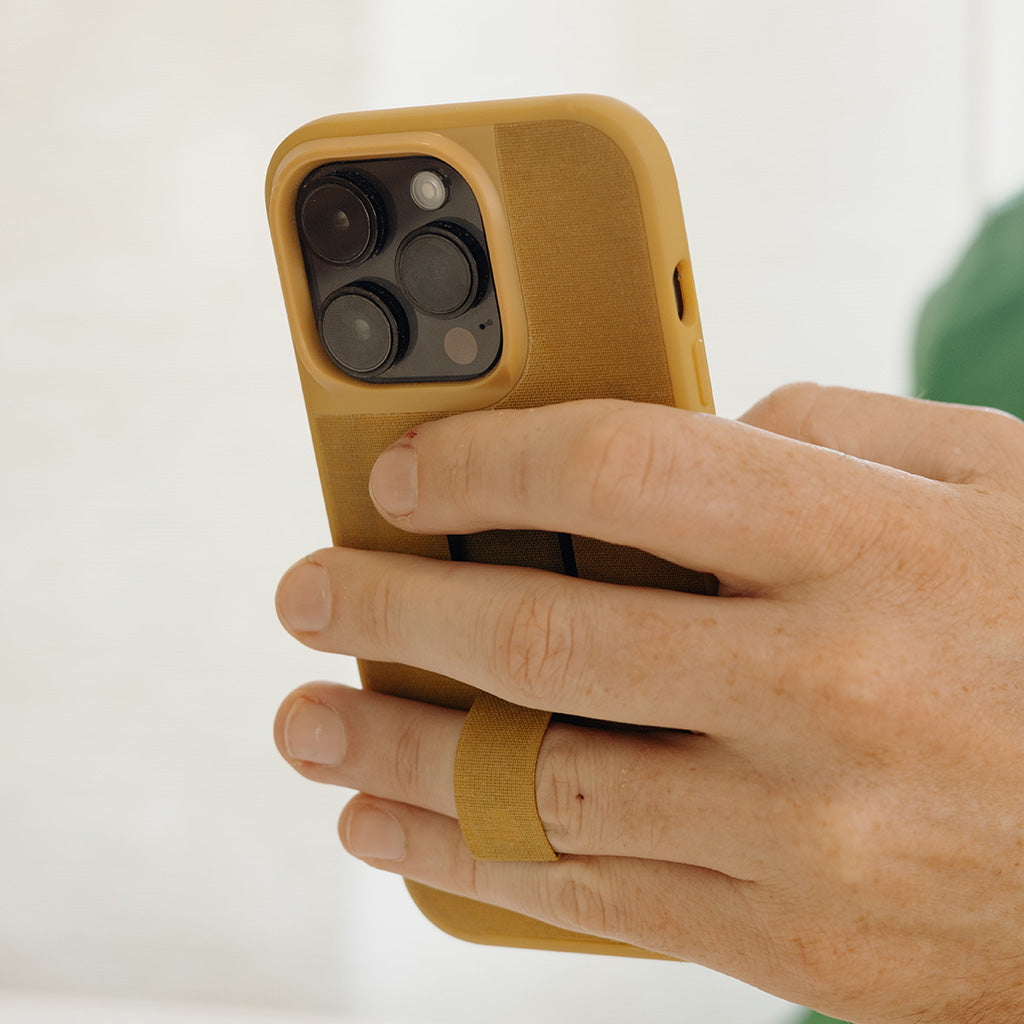 (image), Maria holding his iPhone 12 Pro Max vertically using the finger loop on its Everyday case, M-LC-BJ-CH-1