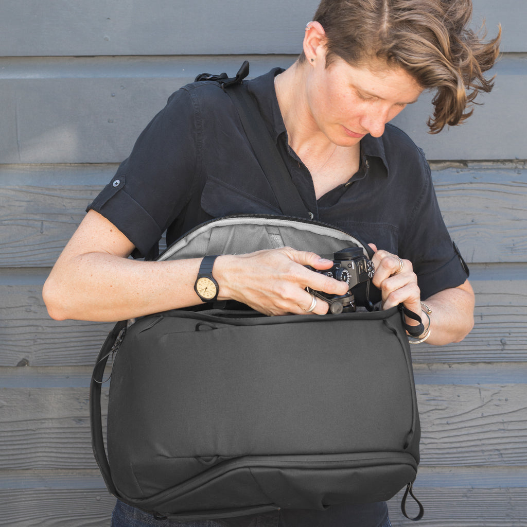 (image), Adrienne getting her camera from the side access zip of the Black Backpack Zip, BEDBZ-15-BK-2, BEDBZ-20-BK-2