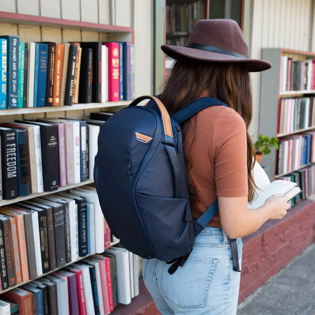 (image), Anne reading a book while wearing her Midnight Backpack Zip, BEDBZ-15-MN-2, BEDBZ-20-MN-2