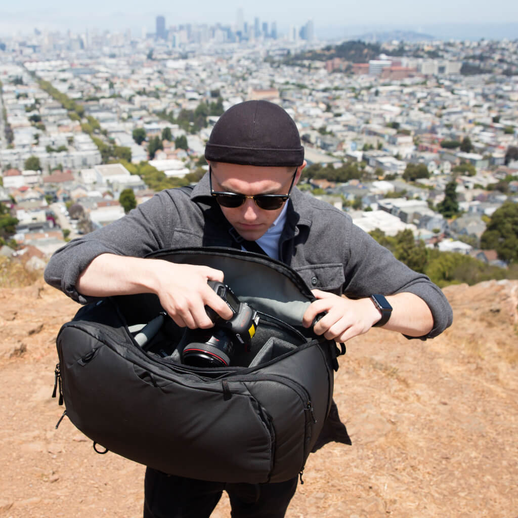 (image), Guy accessing his camera through side soft-lined, zippered pockets, BTR-45-BK-1, black