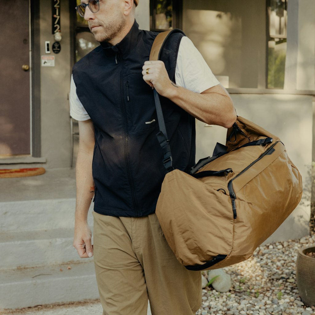 (image), Drew carrying his 50L Coyote Travel Duffel, BTRD-50-CY-1, coyote