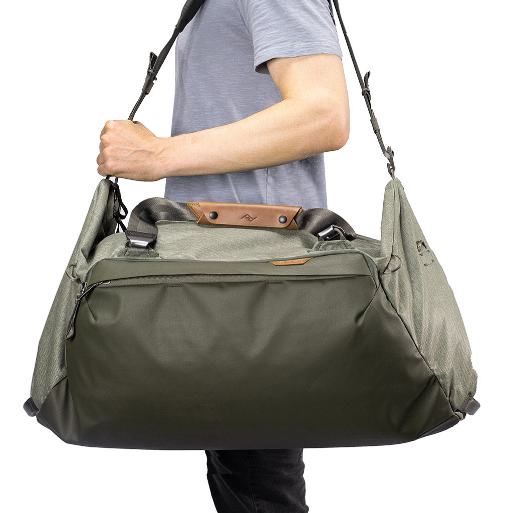 (image), carrying the 65L sage duffel bag using its shoulder strap, BTRD-65-SG-1, sage