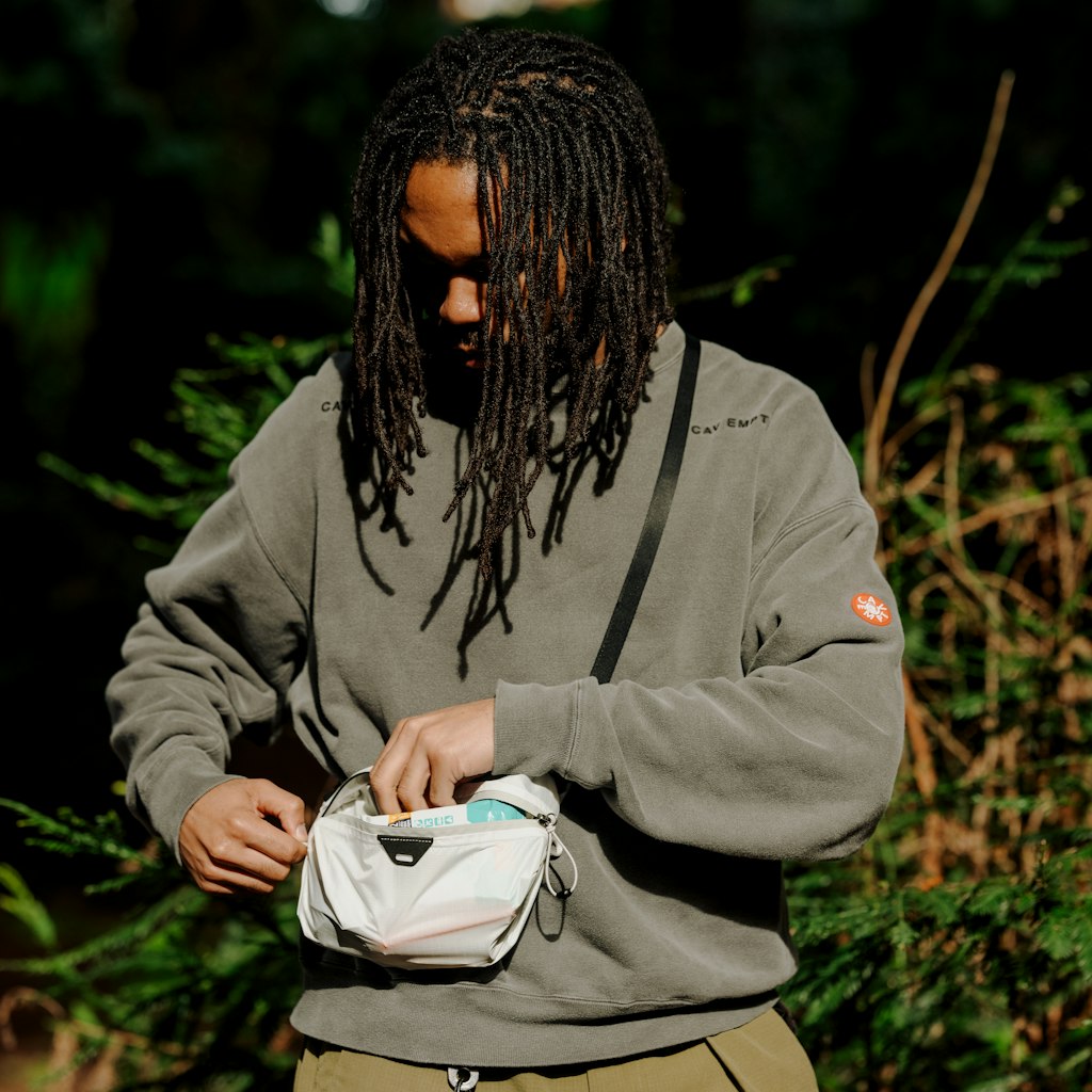 (image), Frontview of a guy modelling the cloud variant of ultralight packing cube, BUP-CD-XXS-1, BUP-CD-XS-1, BUP-CD-S-1